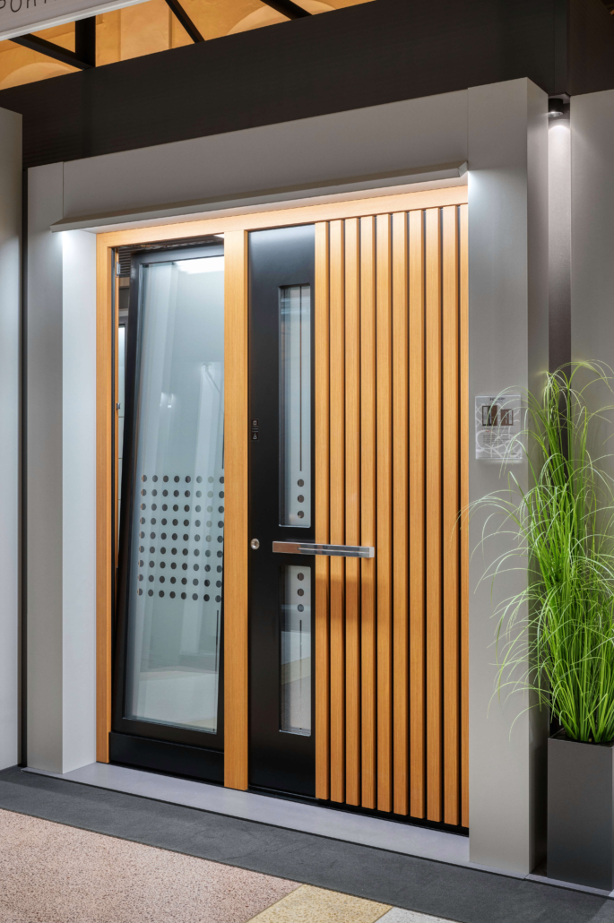 Moderna vhodna vrata z letvami v lesnem dekorju in oknom ob strani