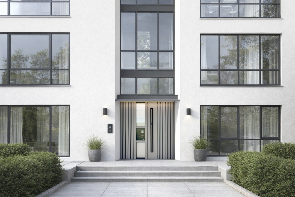 Immeuble résidentiel collectif avec de grandes surfaces vitrées et des portes d’entrée grises